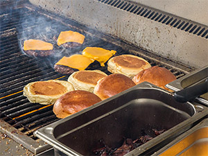 Patties und Buns liegen auf dem Grill