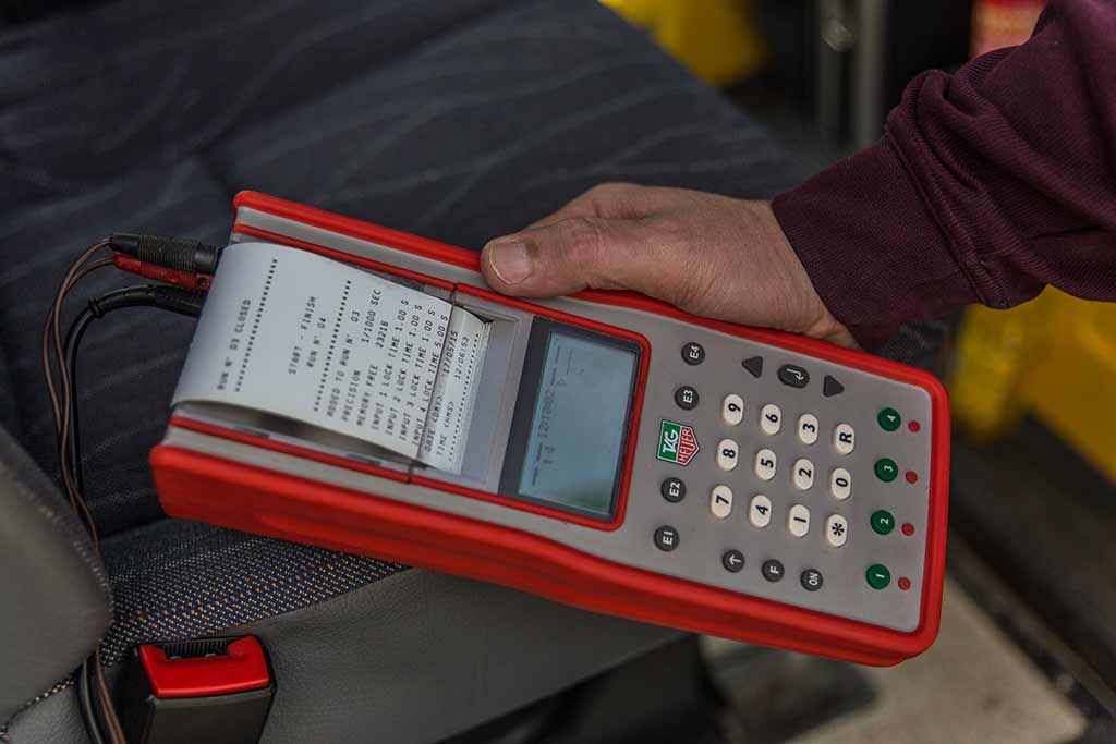 Zeitmessgerät Tag Heuer in Hand mit Protokollausdruck