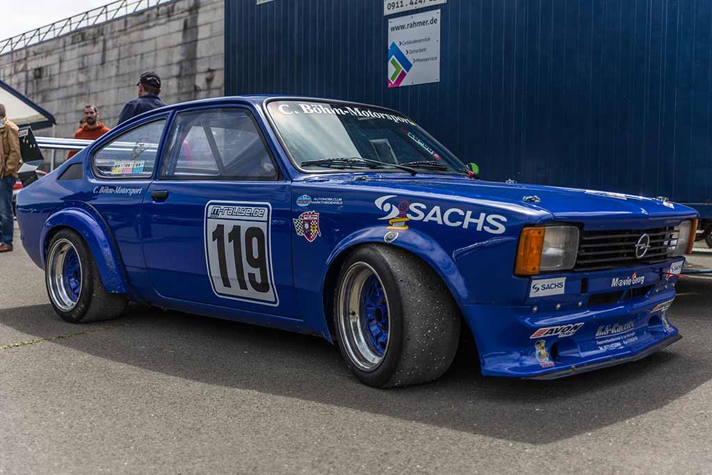 blauer Opel in Fahrerlager vor Container