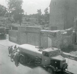 1950 standen von Kadeders Firmengebäude nur noch Ruinen. Eine Traube von Menschen schart sich um einen Tanklastzug, der wohl frisches Trinkwasser verteilt.