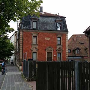 Die südliche Schmalseite der Schweinauer Hauptstraße 71 mit Portal und Inschrifttafel.