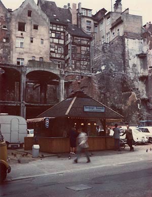 1965 standen nur noch Teile des Eisenbetongerüsts der Kaiserstraße 15 aufrecht. Davor mampften die Passanten Drei im Weggla.